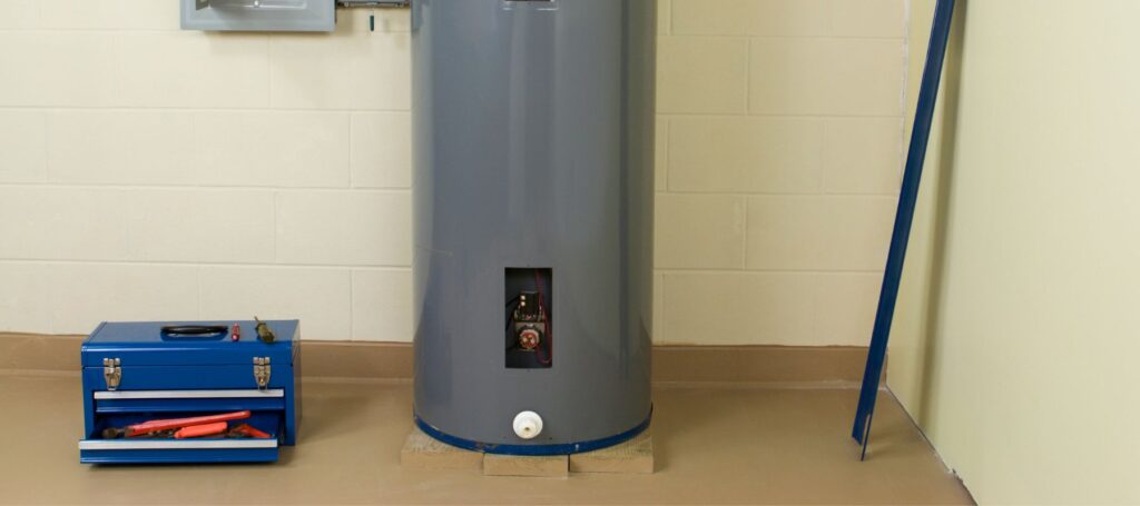 close up of the bottom of a water heater with a blue tool box next to it