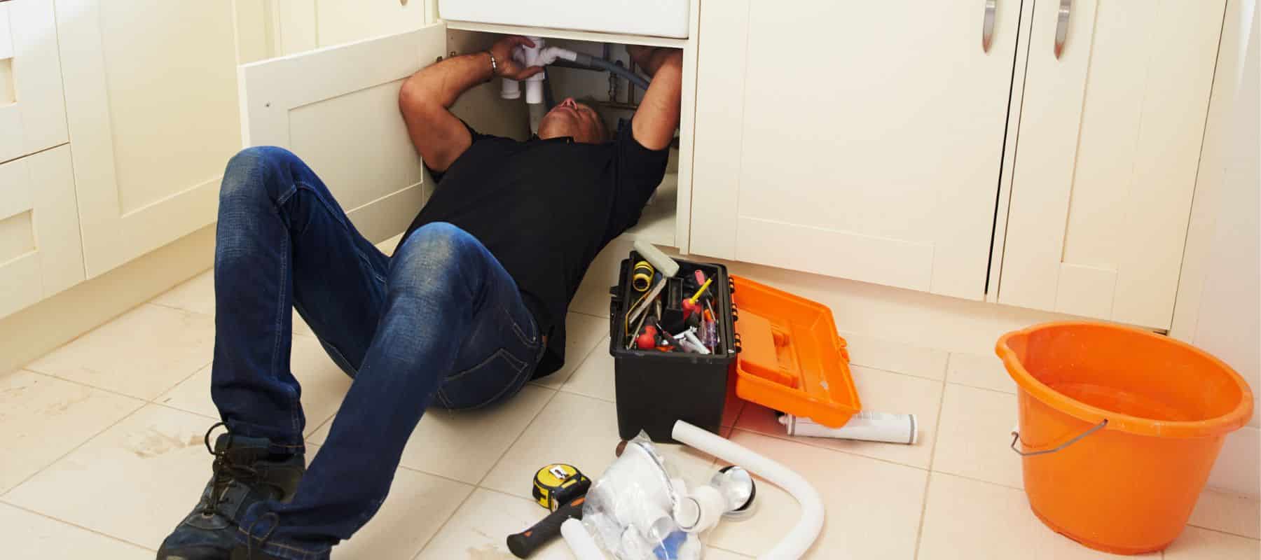 service squad plumber inspecting the plumbing under a sink
