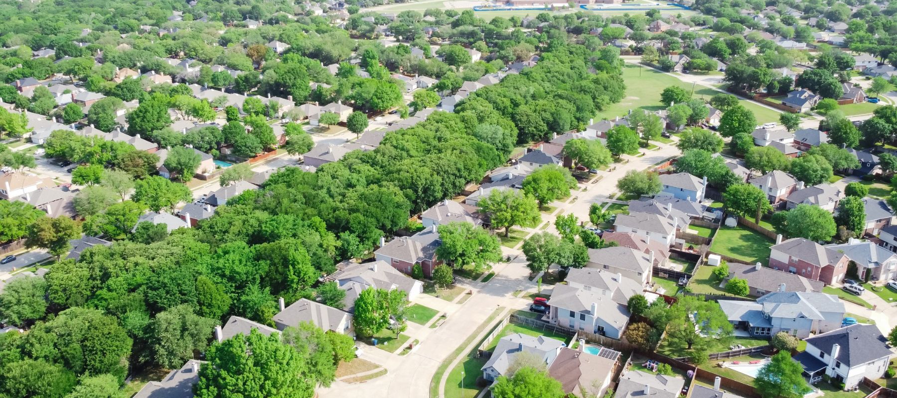 aerial view of a Frisco, TX neighborhood with green trees