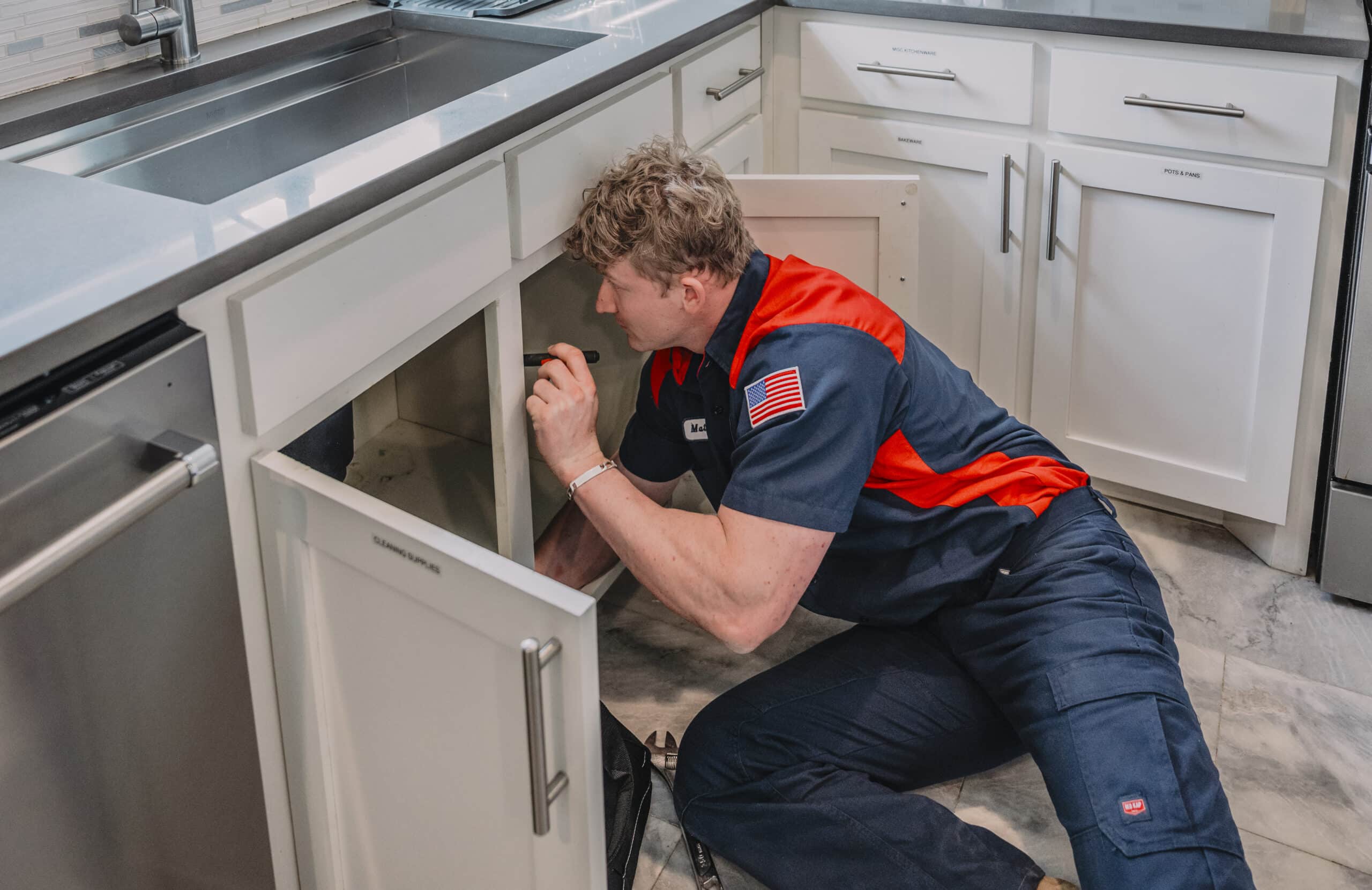 closeup of a service squad plumber performing a drain cleaning service on a residential home