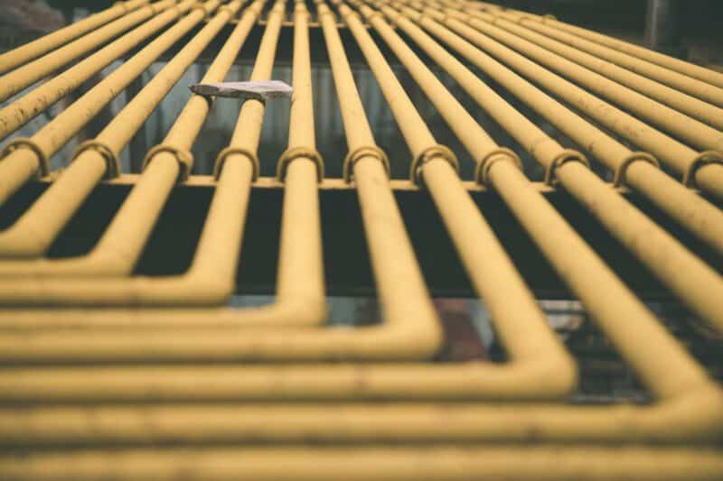 Rows of yellow gas lines installed along an exterior wall