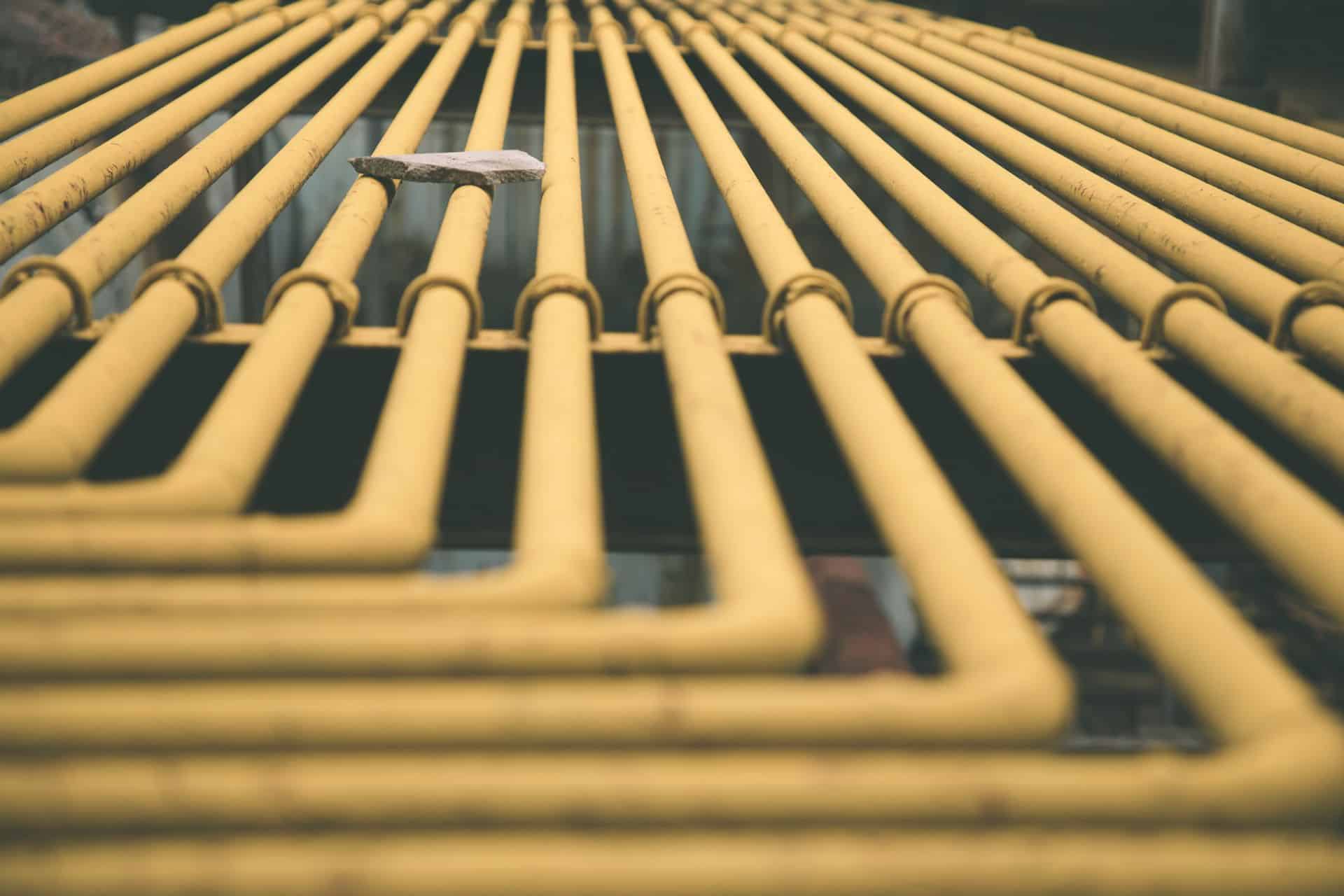 Rows of yellow gas lines installed along an exterior wall