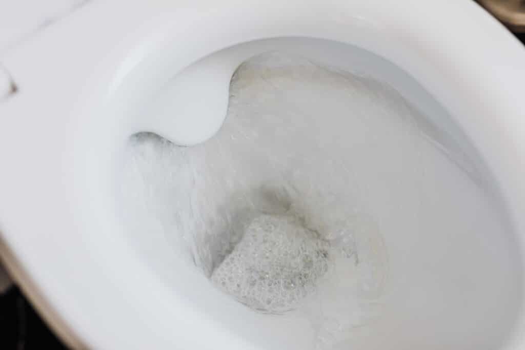Water continuously running into a toilet bowl, showing a toilet that won't stop running.