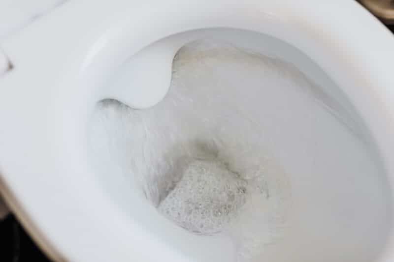 Water continuously running into a toilet bowl, showing a toilet that won't stop running.
