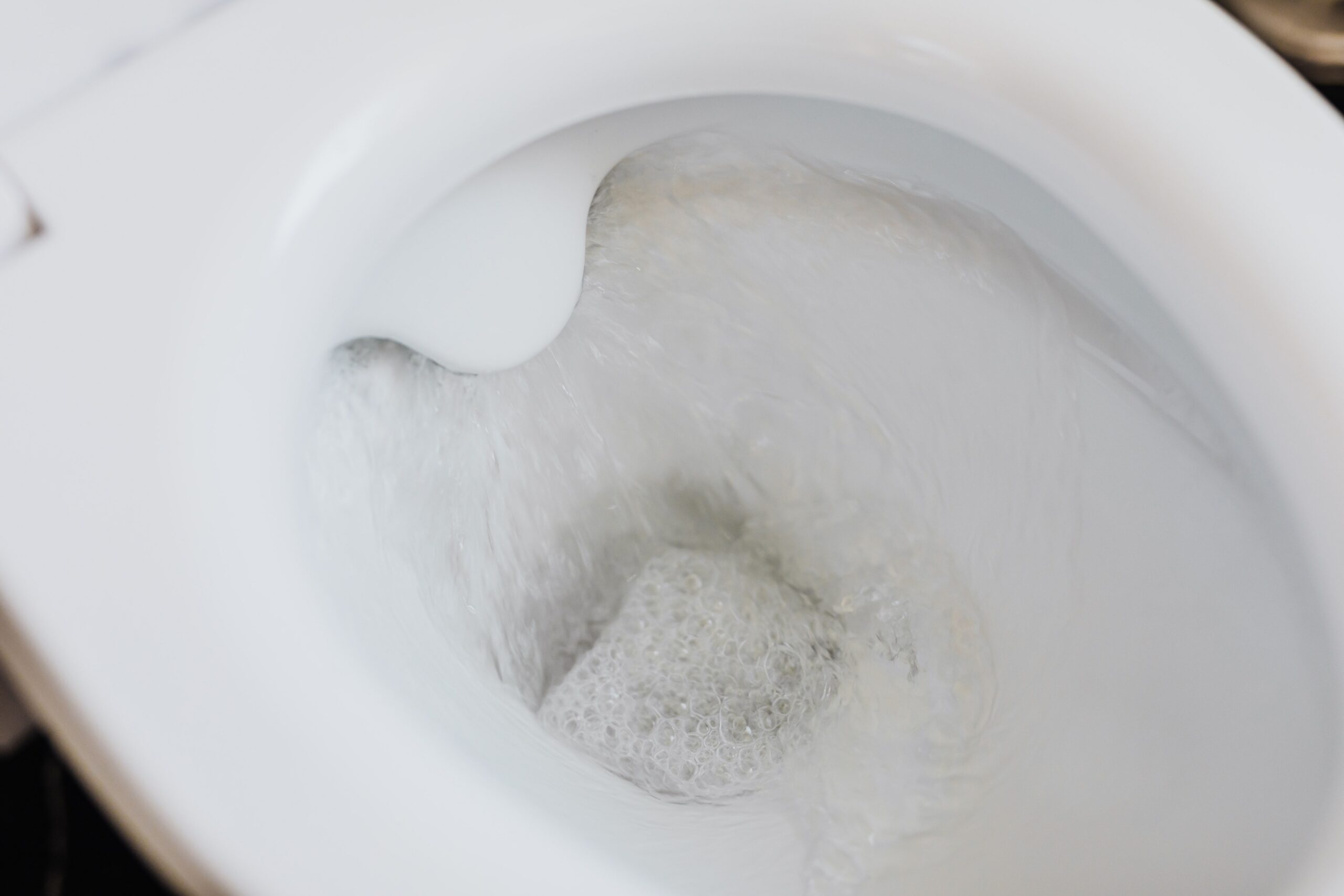 Water continuously running into a toilet bowl, showing a toilet that won't stop running.