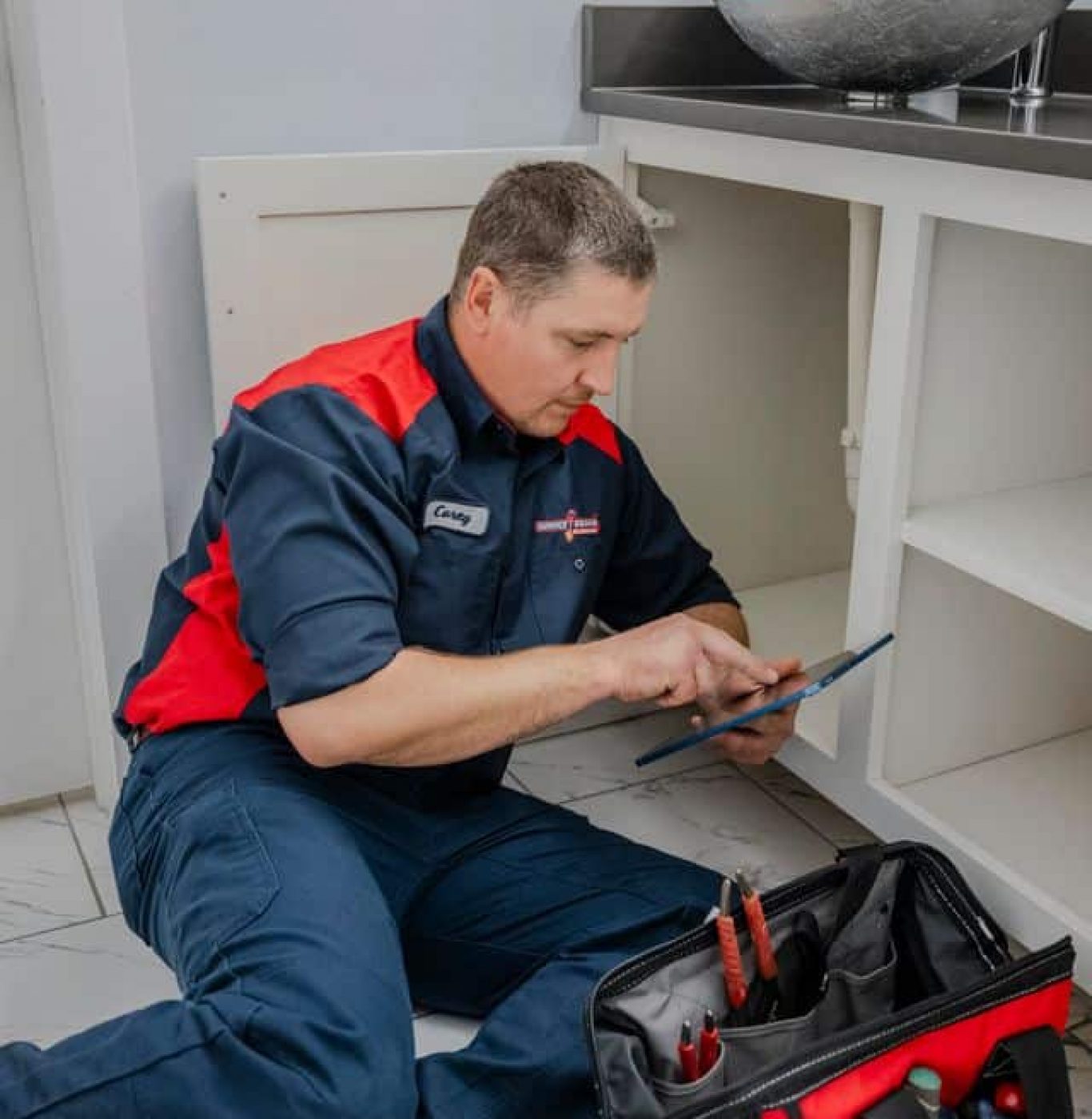 Professional plumber inspecting pipes Service Squad Plumbing