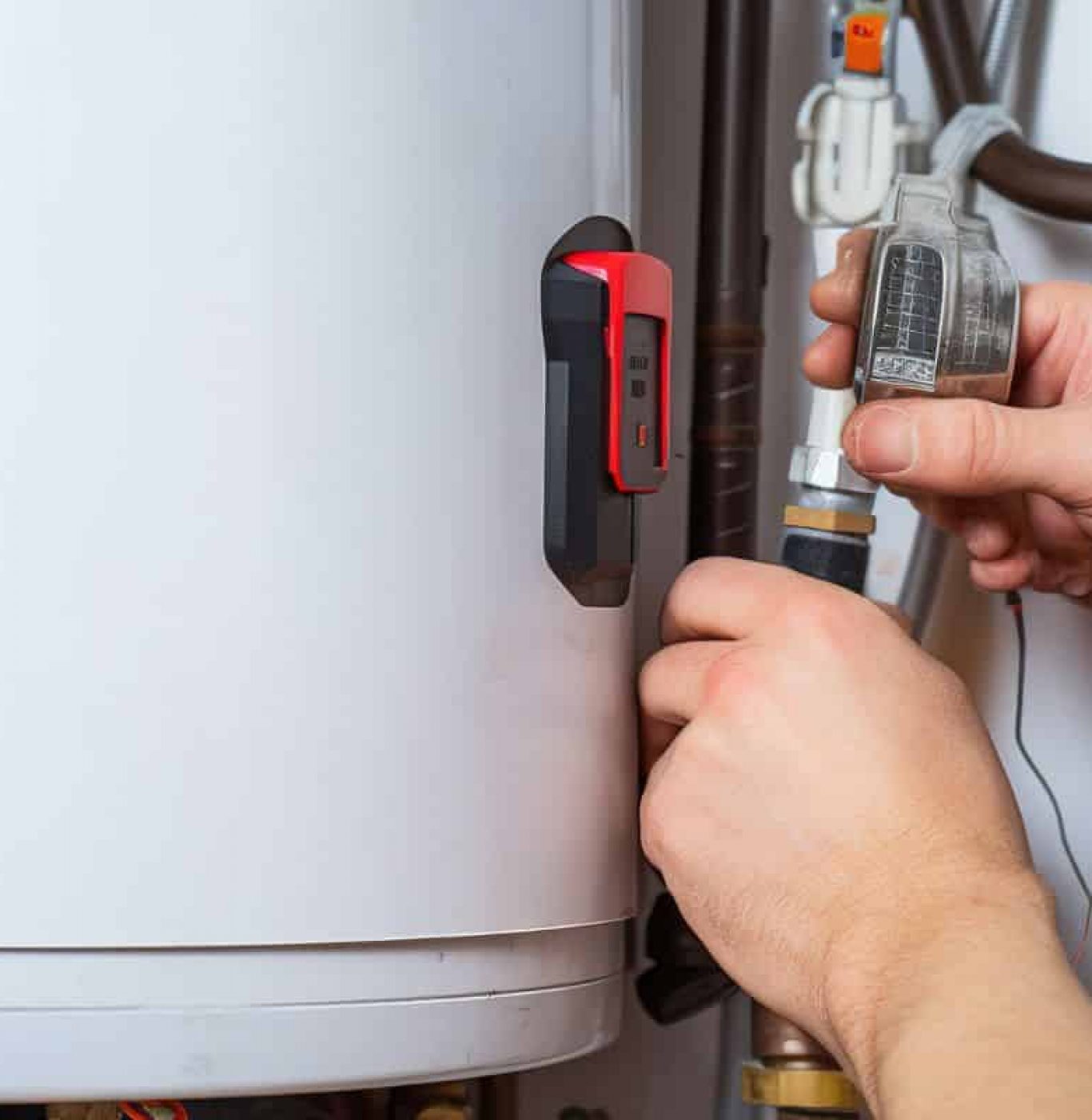 Technician working on pipes connected to a household water heater