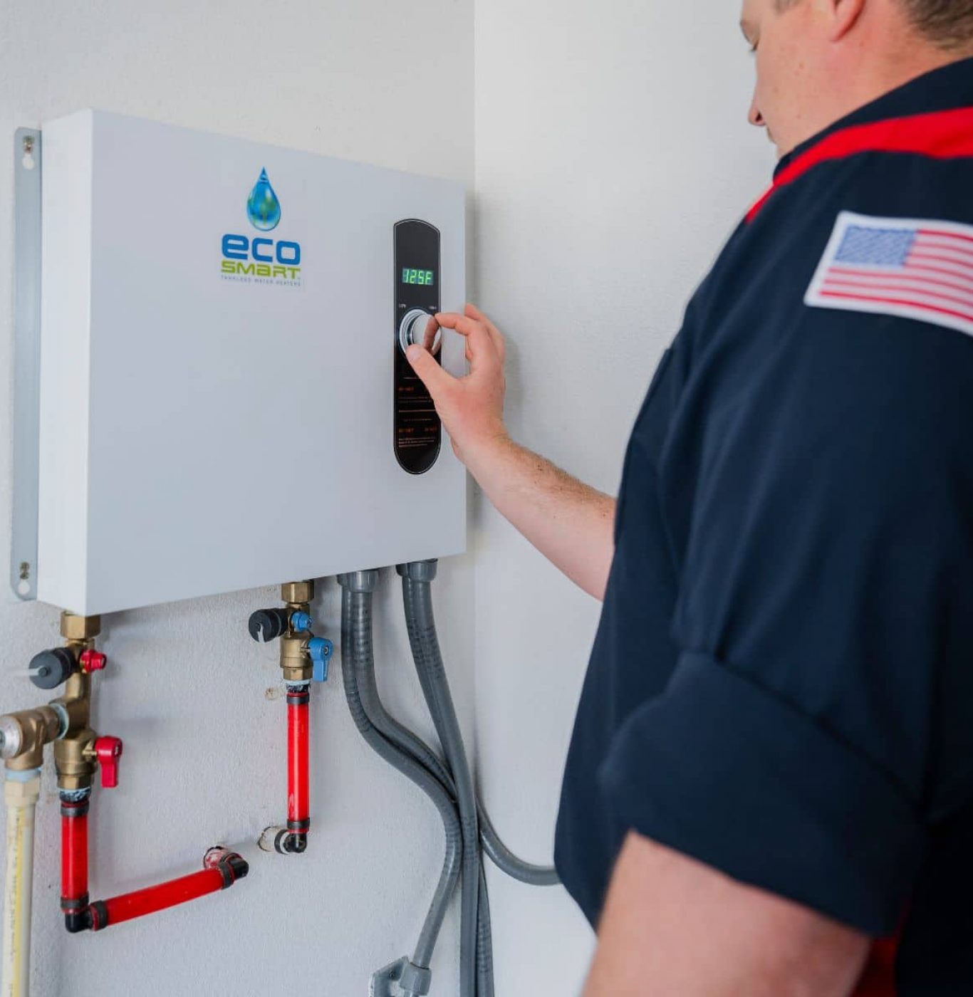 Plumber adjusting the temperature setting on a tankless water heater
